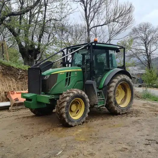 Tractor verde en camino embarrado